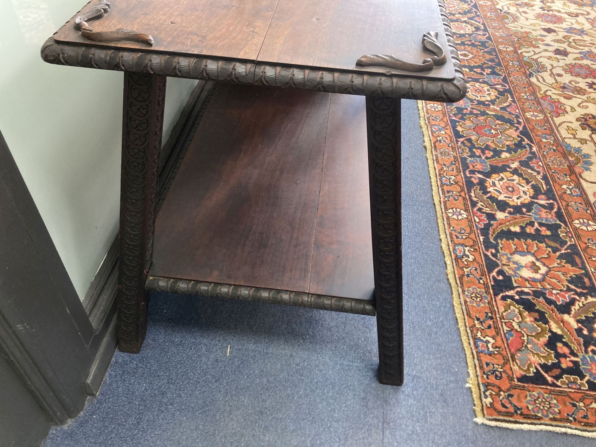 A rectangular carved hardwood two tier table, width 90cm, depth 56cm, height 64cm